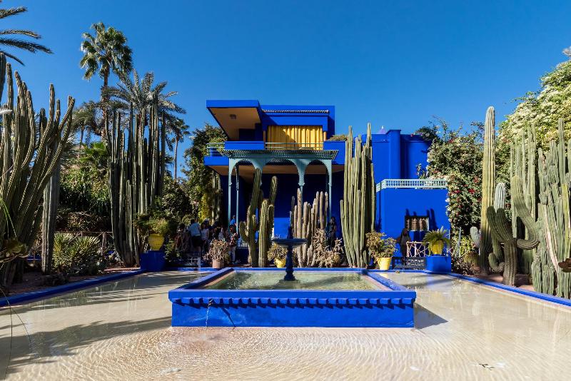 Jardin Majorelle de Marrakech avec ses bâtiments peints du bleu profond iconique, créant une oasis de paix et de beauté.